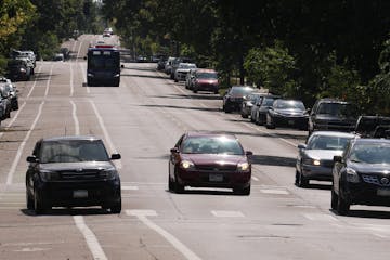 A car at left makes an illegal pass through the bicycle lane as it speeds down Park Avenue near East 36th Street on Thursday in south Minneapolis.