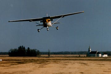 A pilot lands on the grass runway at the Piney-Pinecreek Border Airport in 1993. The runway crosses the border between the United States and Canada.