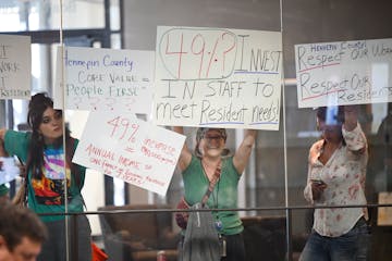 From left, Hennepin County employees Kate Liska, Angela Reid and Tyler Hendrickson protest against a proposed 49% pay raise for county commissioners i