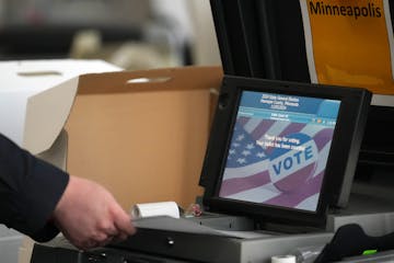 Seth Gellman, elections assistant for Hennepin County, feeds test ballots into a voting machine for the public accuracy test before Election Day at th