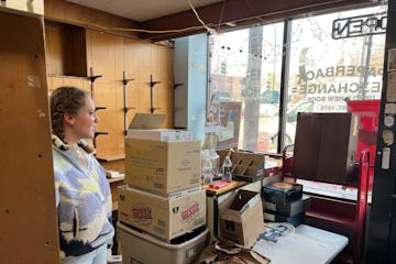 Paperback Exchange store manager Rachel Pedersen looks over the damaged bookstore. A water main break flooded the bookstore and other neighborhood bus