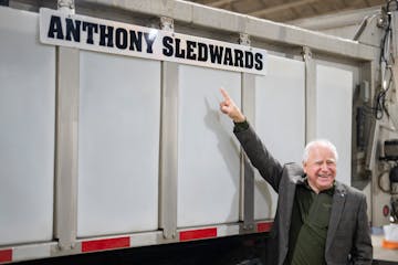 Minnesota Gov. Tim Walz points at the newly named “Anthony Sledwards” snowplow for the metro area after a news conference at Cedar Truck Station i