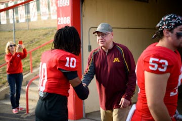 Vice presidential candidate and Minnesota Gov. Tim Walz shakes hands with players on the Mankato West football team before their rivalry game Friday,